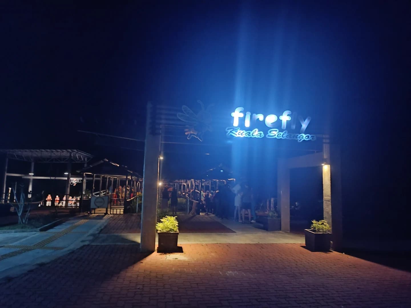 Kampung Kuantan Firefly Park jetty entrance at night, photographed in March 2023; the illuminated sign is not a firefly display